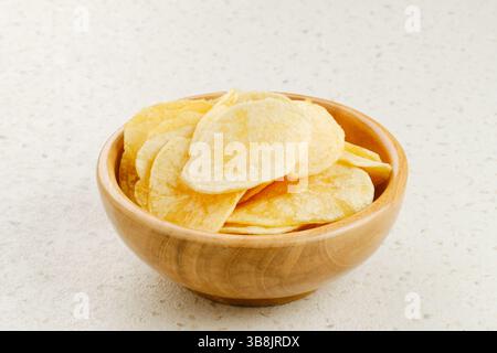 Kartoffelchips, serviert in einer Holzschale auf weißem Hintergrund. Stockfoto