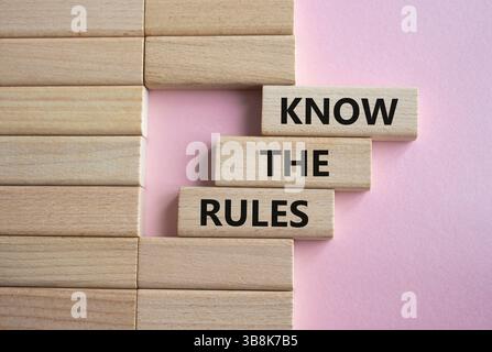 Kennen Sie das Regelsymbol. Holzblöcke mit Worten kennen die Regeln. Schöner rosafarbener Hintergrund. Und kennen Sie das Regelkonzept. Kopierbereich. Stockfoto