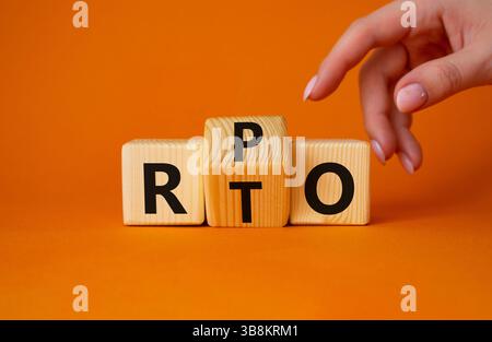 RPO vs. RTO-Symbol. Geschäftsmann zeigt auf gedrehte Holzwürfel mit den Worten RTO zu RPO. Wunderschöner orangefarbener Hintergrund. Geschäftskonzept. Kopierbereich Stockfoto