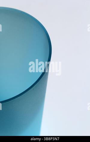 Nahaufnahme eines blauen Glases vor weißem Hintergrund Stockfoto