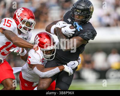 25. November 2023: Kobe Hudson (2) wird vom Houston Cougars Linebacker Hasaan Hypolite (5) angegriffen, nachdem er während des NCAA-Fußballspiels in der ersten Halbzeit zwischen den Houston Cougars und den UCF Knights im FBC Mortgage Stadium in Orlando, FL. Romeo T Guzman/CSM (Kreditbild: Stockfoto