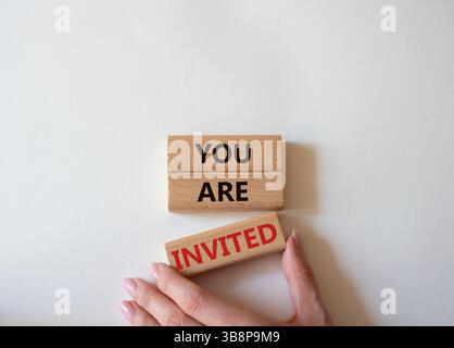 Symbol „Sie sind eingeladen“. Holzblöcke mit Worten, die Sie eingeladen sind. Schöner weißer Hintergrund. Geschäftsmann Hand. Business und Sie sind eingeladen Konzept. Stockfoto