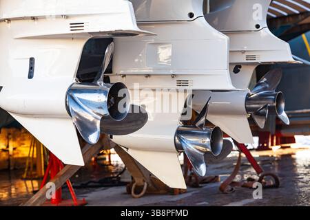 Motorpropeller für Motoryachten und Boote in Nahaufnahme. Die Motoren sind am Heck des Motorbootes montiert. Reparieren Sie ein Boot in einem Trockendock. Stockfoto
