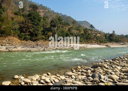 Malerischer Blick auf den Trishuli River in Nepal, der schnell durch eine felsige Landschaft und üppige grüne Hügel fließt. Stockfoto