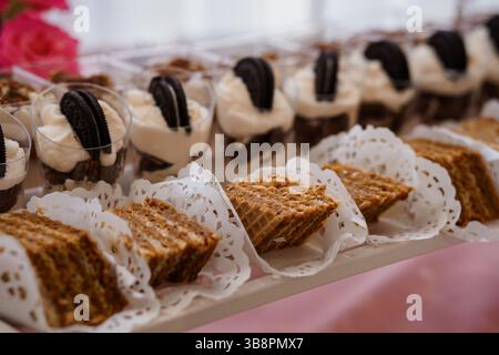 Ein köstlicher Dessertaufstrich mit Schokoladen-Cupcakes mit Oreo-Belag, individuellen Brownie-Tassen und Blondie-Quadraten, präsentiert auf einem silbernen tr Stockfoto