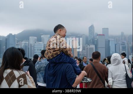 Vater und Sohn teilen einen freudigen Moment mit Blick auf die Skyline von Hong Kong Island Stockfoto