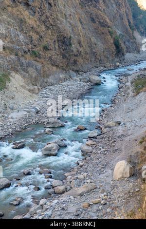 Ein Fluss fließt durch eine felsige Schlucht, der sich seinen Weg durch die Landschaft schneidet. Die Kraft der Natur prägt das Gelände. Stockfoto