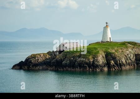 Frühlingsnachmittag am TWR Bach Leuchtturm auf Llanddwyn Island, Anglesey, Wales. Die Gipfel von Snowdonia erheben sich in der Ferne. Stockfoto