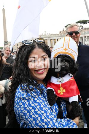 Eine Frau posiert mit ihrem Hund Romeo, gekleidet als Papst, am zweiten Tag des Konklaves im Vatikan am 8. Mai 2025 auf dem Petersplatz. Die 133 Kurfürsten haben die Sixtinische Kapelle betreten, um das Konklave zu besuchen, das den nächsten und den 267. Papst wählen wird. Foto: Eric Vandeville/ ABACAPRESS.COM Credit: Abaca Press/Alamy Live News Stockfoto