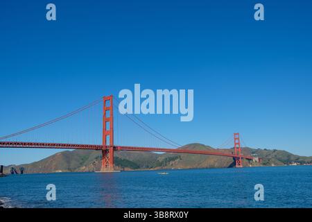 Die Golden Gate Bridge steht hoch, während Kajakfahrer unter ihnen paddeln und einen sonnigen Tag in San Francisco genießen. Stockfoto