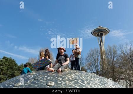 Aaron Morton (Mitte) sitzt auf dem International Fountain mit einer Kindergemeinschaft im Seattle Center während der „Hands Off!“ Rallye in Seattle Stockfoto