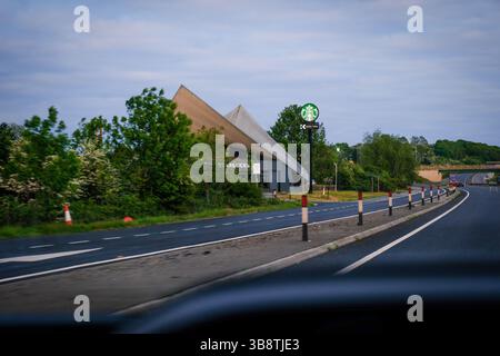 07. Mai 2025 - Peterborough, Großbritannien - Blick auf die Starbucks Drive Thru-Schilder vom Fahrersitz eines Autos auf der Autobahn Stockfoto