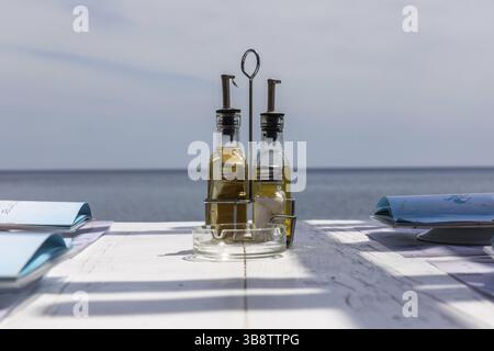 Flasche mit Essig und Öl auf einem Restauranttisch, Perissa, Insel Santorin, Kykladen, Griechenland, Europa Stockfoto