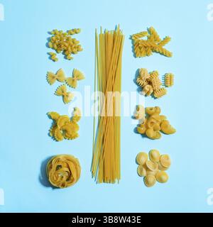 Pasta Concent. Verschiedene Nudelsorten auf blauem Hintergrund. Kreatives Layout Pasta Guide Konzept. Essen knallt. Pasta Art. Draufsicht oder flache Lagen Stockfoto