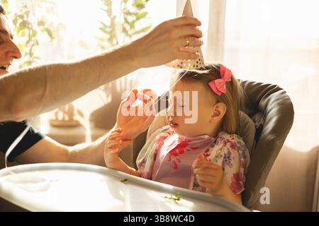 Schönes Mädchen in einem Kinderstuhl zu Hause Stockfoto