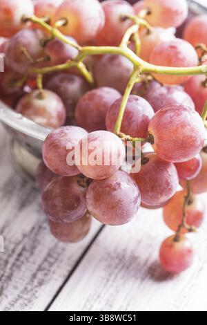 Große rote Trauben in Sieb auf dem Holz Hintergrund Stockfoto