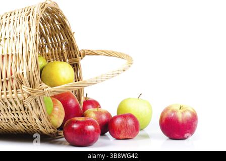 Korb und Äpfel sind auf weißem Hintergrund Streuung. Symbol des Herbstes Stockfoto