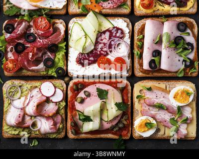 Satz von acht verschiedenen Sandwiches mit Fleisch in quadratische Form. Top View oder flach. Sortiment Fleisch Toast auf schwarzem Hintergrund. Idee, kreative Konzept Stockfoto
