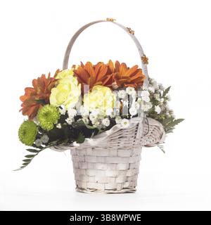 Wunderschöner Blumenstrauß im weißen Korb auf weißer Tischdecke Stockfoto