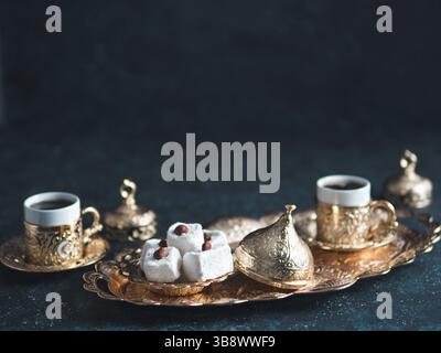 Türkischer Kaffee mit Delight und traditionelle Kupferservierung auf dunklem Hintergrund. Verschiedene traditionelle türkische Dilight oder Lokum und türkischen Kaffee in Stockfoto