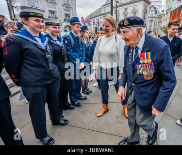 London, Großbritannien. Mai 2025. Der Veteran Mervyn Kersh im Alter von 100 Jahren (kommt zu einer Ehrenwache der Kadetten, einschließlich Mitglieder der jüdischen Jungen- und Mädchenbrigade), der im Film zu sehen ist und an den Landungen der Normandie teilnahm und später Zeuge der Befreiung des Konzentrationslagers Bergen-Belsen war - VE80 Film Tribute für VE Day im Piccadilly Circus um 15 Uhr, als Churchill vor 80 Jahren Frieden in Europa erklärte. Der Film wurde von Ocean Outdoor, The Together Coalition und M C Saatchi produziert und auf den Piccadilly Lights gezeigt. Guy Bell/Alamy Live News Stockfoto