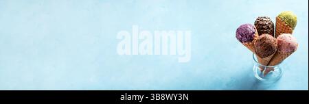 Verschiedene Eiskugeln in den Kegeln, Kopierraum. Farbenfrohe Eiscreme in Schokoladen-, Erdbeeren-, Heidelbeeren-, Pistazien- oder Matcha-Keksen, Schokoladen-Keksen Stockfoto