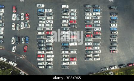 Draufsicht auf viele Autos, die auf einem Asphaltparkplatz in der Stadt geparkt sind. Draufsicht von oben, viele Autos sind geparkt Stockfoto