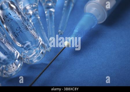 Injektion mit Impfstoff Closeup auf blauem Hintergrund Stockfoto