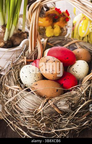 Braunen, roten und gelben Eiern in Korb, Ostern Dekoration Stockfoto