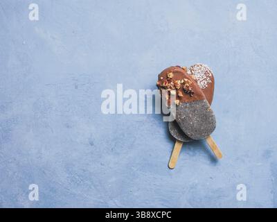 Chia Popsicle mit Schokolade auf blauem Hintergrund. Gesundes Rezept und Idee hausgemachtes veganes Eis mit Eiswürfeln. Osterdessert Idee. Platz für Text kopieren. Stockfoto