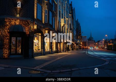 Stimmungsvolle Nachtszenen von der Bryggen Wharf in Bergen, Norwegen, mit gemütlichen Geschäften, beleuchteten Gassen und historischen Holzgebäuden in warmen Lichtern Stockfoto