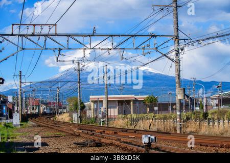 Eisenbahngleise und Stromleitungen mit dem Fuji an einem sonnigen Tag, Japan Stockfoto