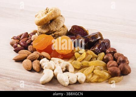 Getrockneten Früchten und Nüssen Haufen auf Holztisch Stockfoto