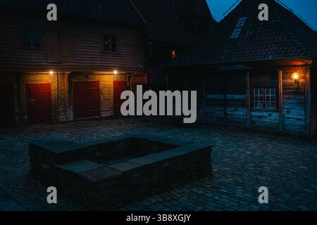 Stimmungsvolle Nachtszenen von der Bryggen Wharf in Bergen, Norwegen, mit gemütlichen Geschäften, beleuchteten Gassen und historischen Holzgebäuden in warmen Lichtern Stockfoto