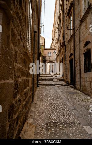 Steinbogengiebel, Kopfsteinpflastertreppen und Bogengang in der mittelalterlichen Stadt Dubrovnik, Kroatien. Stockfoto