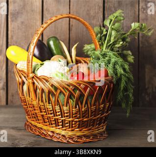 Korb mit Gemüse und frischen Kräutern auf dem Holz Hintergrund Stockfoto