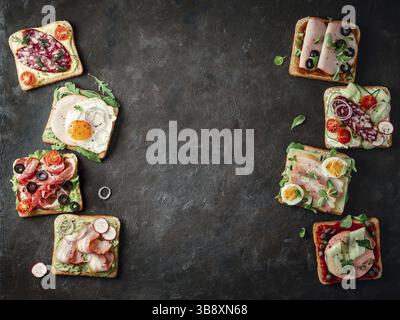 Set aus acht verschiedenen Sandwiches mit Fleisch, kopieren Raum für Design oder Text in der Mitte. Draufsicht oder flaches Lay. Fleischtoastgerichte auf schwarzem Hintergrund Stockfoto