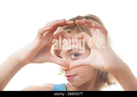 Ein blondes Mädchen zeigt Herzform mit bunten Nägeln Stockfoto