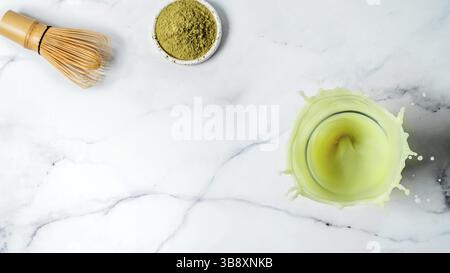 Hausgemachte Eistee Matcha Latte mit Spritzern auf weißem Hintergrund. Top View oder flach. Kopieren Sie Platz für Text oder Design Stockfoto