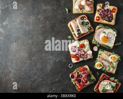 Set aus acht verschiedenen Sandwiches mit Fleisch, kopieren Raum für Design oder Text. Draufsicht oder flaches Lay. Fleischtoastgerichte auf schwarzem Hintergrund. Idee, cr Stockfoto