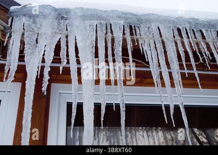 Eiszapfen auf dem Dach nach Frostkissen. Es ist sehr gefährlich Stockfoto