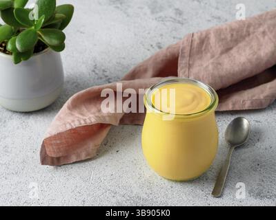 Gelbe Mangolassi auf grauem Hintergrund. Indisches Mango-Joghurtgetränk mit Kopierraum Stockfoto