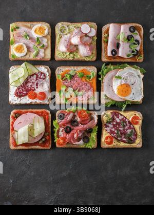 Set aus acht verschiedenen Sandwiches mit Fleisch in quadratischer Form, kopieren Raum für Text. Draufsicht oder flaches Lay. Fleischtoastgerichte auf schwarzem Hintergrund. Id Stockfoto