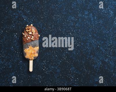 Chia Popsicle mit rohen Karotten Kuchen und Schokolade auf dunkelblauem Hintergrund. Gesundes Rezept und Idee hausgemachte vegan popsicle Eis. Ostern dessert-id Stockfoto