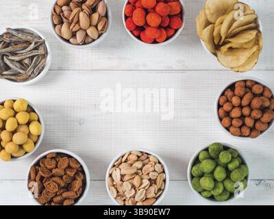 Sortiment von verschiedenen Snack für Bier, Wein, Party. Erdnüsse in Coconut Glasur, grüne vasabi, rote scharfe Chili, gelben Käse Glasur, Chips, Pistazie, Stockfoto