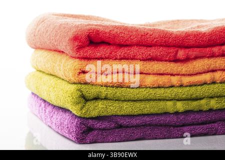 Stapel von farbenfrohe Handtücher isoliert auf weiss Stockfoto