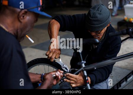 Juli 2023: Von rechts: Huberth Espinoza, 65, und Johnny Lloyd, 61, Arbeiten an einem Fahrrad, das Lloyd am 21. Juni 2023 an Huberth vor der Polizeiwache des 5. Bezirks in Chicago verkaufte. (Bild: © Armando L. Sanchez/Chicago Tribune via ZUMA Press Wire) Stockfoto