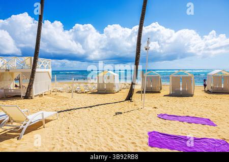 Private Loungebereiche mit Sonnenliegen und weißen Baldachinen am Sandstrand mit Blick auf den Atlantik. Dominikanische Republik. Punta Cana. Stockfoto