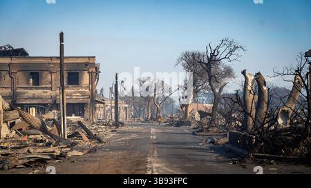 August 2023, Lahaina, Maui, Hawaii, USA: zerstörte Gebäude und verbrannte Bäume umgeben das Gebiet nach dem Brand, während die Bewohner am Mittwoch eine Straße entlang gehen. Große Teile der Stadt Lahaina wurden durch das Waldfeuer, das Dienstagnacht wütete, fast bis zur Unkenntlichkeit verändert.die Zahl der Todesopfer durch die sich schnell bewegenden Waldbrände aus Hawaii ist auf 53 Menschen gestiegen. (Bild: © Jack Truesdale/Civil Beat/ZUMA Press Wire) Stockfoto