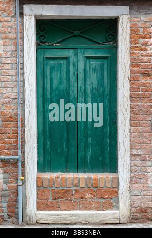 Alte grüne Holztür in Ziegelmauer Stockfoto